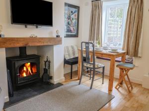 a living room with a fireplace and a dining room table at Old Ropemakers Cottage in Bridport