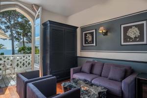 a living room with a purple couch and chairs at La Villa Mauresque in Saint-Raphaël