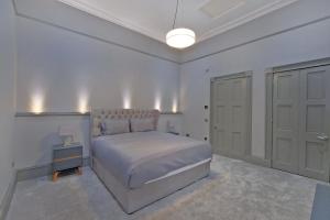 a white bedroom with a large bed and a closet at Kirkton House in Kirkton of Skene