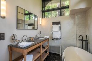 a bathroom with a sink and a tub and a mirror at La Villa Mauresque in Saint-Raphaël