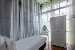 a bedroom with a bed and a window with a mirror at La Villa Mauresque in Saint-Raphaël