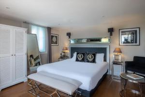 a bedroom with a large white bed and a chair at La Villa Mauresque in Saint-Raphaël
