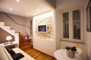 a living room with a television and a painting on the wall at Apartments & Studios Scalini in Dubrovnik