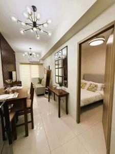 a living room with a bed and a dining room at Stylish and Comfy Condominium in Manila