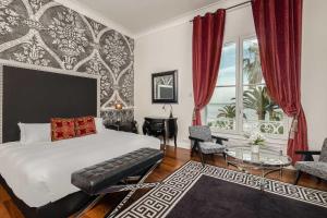 a bedroom with a bed and a desk and a window at La Villa Mauresque in Saint-Raphaël