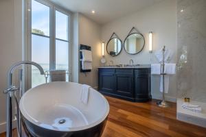 a large bathroom with a tub and a sink at La Villa Mauresque in Saint-Raphaël