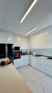 a white kitchen with a plate of food on a counter at Sea View Luxury Ap Solistice in Chania Town +10 photos