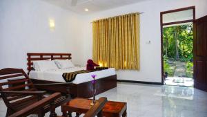 una camera da letto con un letto, un tavolo e delle sedie di Sigiriya Dreamscape Villa a Sigiriya