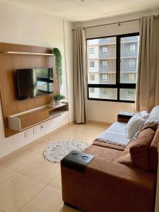 a bedroom with a large bed and a flat screen tv at Apto condomínio conforto e ótima localização in Lucas do Rio Verde