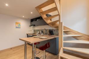 a small kitchen with a wooden table and a wooden stairway at Duplex une chambre calme, proche commodités in Lille