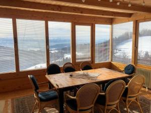 a dining room with a table and chairs and windows at Mountain house with a view in Christofberg