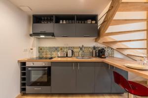 a kitchen with gray cabinets and a wooden counter top at Duplex une chambre calme, proche commodités in Lille