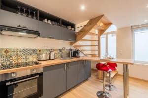 a kitchen with gray cabinets and a wooden counter top at Duplex une chambre calme, proche commodités in Lille