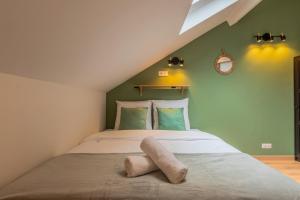 a bedroom with a large bed with green walls at Duplex une chambre calme, proche commodités in Lille