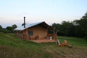 a yurt with a deck in a field at Seven Hills Hideaway - One Bedroom in Abergavenny
