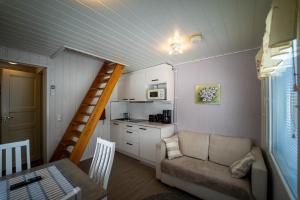 ein Wohnzimmer mit Sofa und eine Küche in der Unterkunft Paimentupa in Kolinkylä