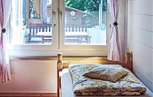 a small bed in a room with a window at Stunning Home In Penzlin Ot Wustrow in Wustrow +4 photos