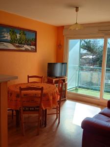 ein Esszimmer mit Tisch und Fernseher in der Unterkunft Appar bray-dunes in Bray-Dunes