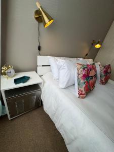 a bedroom with a bed with a lamp and a night stand at Melk Tert - Paarl - Self Catering Apartment in Paarl