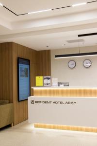 an office lobby with a reception desk and a sign that reads la retreatient hotel at Resident Hotel Abay in Almaty