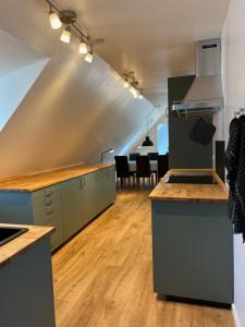 an attic kitchen with wooden floors and a dining room at Søndervang, lejlighed 1sal in Svinninge