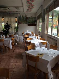 een restaurant met tafels en stoelen met witte tafelkleden bij Locanda Irene in Monte San Pietro