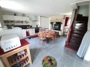 a kitchen with a table and a dining room at Gîte des oiseaux in Préchac