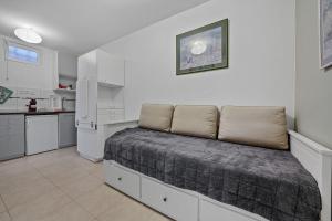 Un dormitorio con una cama y una cocina con nevera. en Welcome to Village Parisien 1, en Saint-Maur-des-Fossés