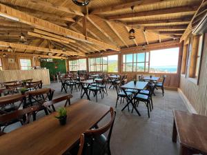 a restaurant with wooden tables and chairs and windows at İnebolu Eskonak Otel in Inebolu