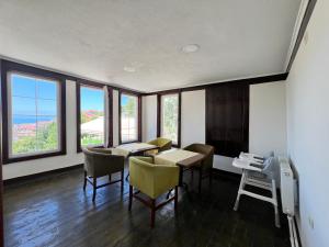 a dining room with a table and chairs and windows at İnebolu Eskonak Otel in Inebolu