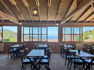 a dining room with tables and chairs and windows at İnebolu Eskonak Otel in Inebolu