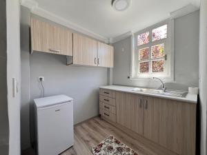 a kitchen with wooden cabinets and a sink and a window at İnebolu Eskonak Otel in Inebolu
