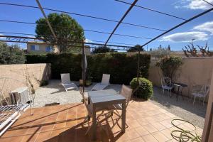 a patio with a table and chairs in a backyard at At Tinou's spacious quiet house with garden for 2 people in LʼIsle-sur-la-Sorgue