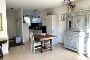 a kitchen with a wooden table and chairs in it at At Tinou's spacious quiet house with garden for 2 people in LʼIsle-sur-la-Sorgue +11 photos