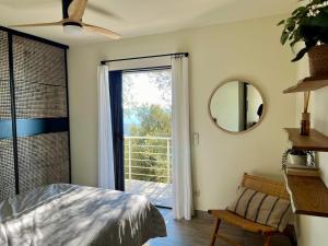 una camera da letto con un letto e una grande finestra di Maison avec vue imprenable a Olmeto