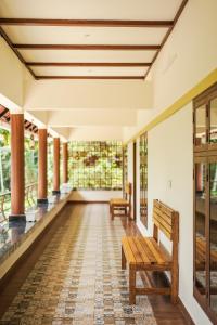 an empty porch with benches and windows at Swasta Royal Villas Wayanad in Kaniyāmbetta