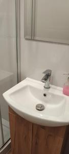 a white sink in a bathroom with a mirror at Apartament Ducha NO'7 in Toruń +26 photos