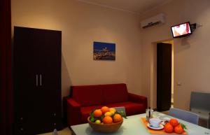 トラーパニにあるパラッツォ デイ コルサリのリビングルーム(赤いソファ付)、テーブルにフルーツを用意しています。