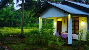 una piccola casa con un tavolo di fronte di Sigiriya Dreamscape Villa a Sigiriya