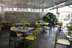 a dining room with tables and yellow chairs at Central Hotel in Saint-Denis