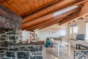 a living room with a stone wall and wooden ceilings at Domus in Como by Rent All Como in Como