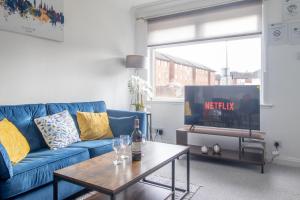 a living room with a blue couch and a table at Spacious 2-Bed City Home Free Parking & Stadiums in Glasgow