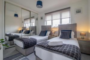 a bedroom with two beds and a mirror at Spacious 2-Bed City Home Free Parking & Stadiums in Glasgow