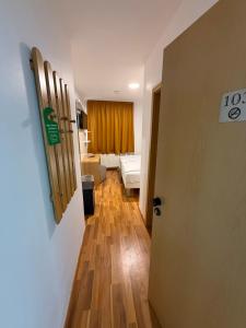 a hallway with a door to a room with a bathroom at Hotel Eurocity in Bruchköbel +4 photos