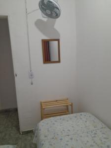 a bedroom with a bed and a mirror on the wall at Pensionato Nosso lar in Jandira