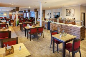 a restaurant with tables and chairs and a bar at Frieslandstern - Ferienhof und Hotel in Wangerland