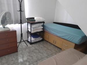 a bedroom with a bed and a desk with a fan at Pensionato Nosso lar in Jandira