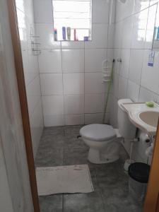 a bathroom with a toilet and a sink at Pensionato Nosso lar in Jandira