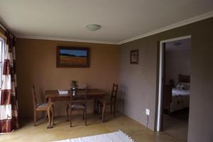 a dining room with a table and chairs and a bed at Brambleberry Farm in Riebeek-Kasteel
