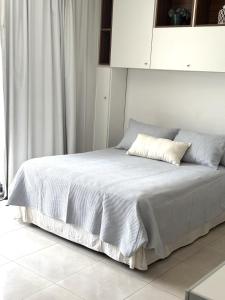 a bedroom with a white bed with white sheets and a window at Departamento Barrio Plaza Colon in Chivilcoy